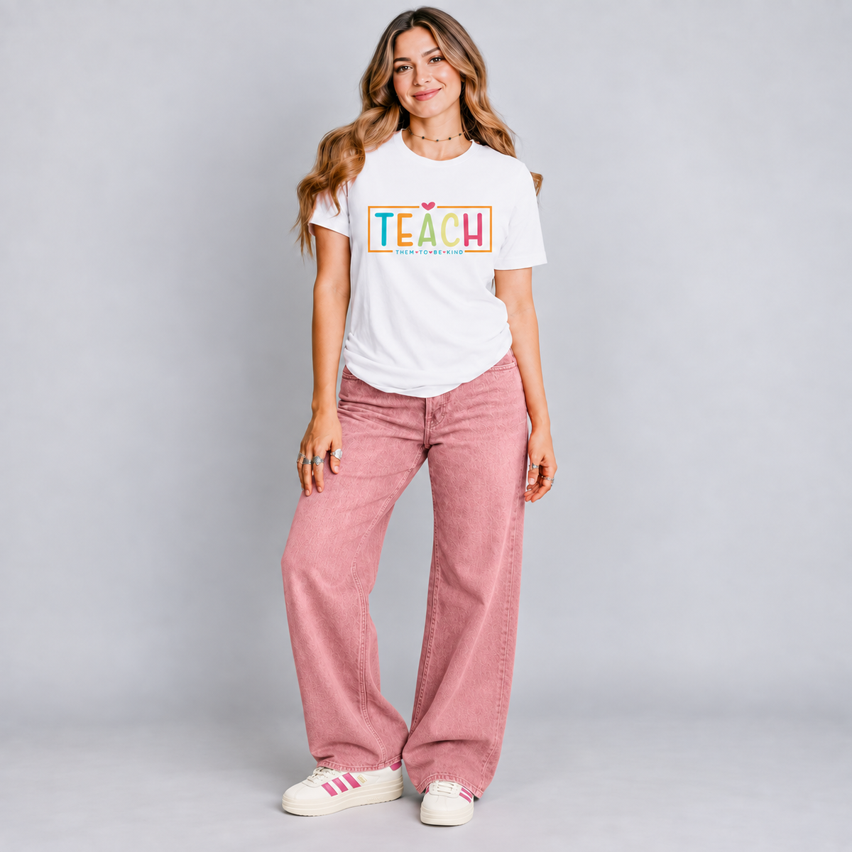 Teach Them to Be Kind con pantalón y tenis, foto de conjunto