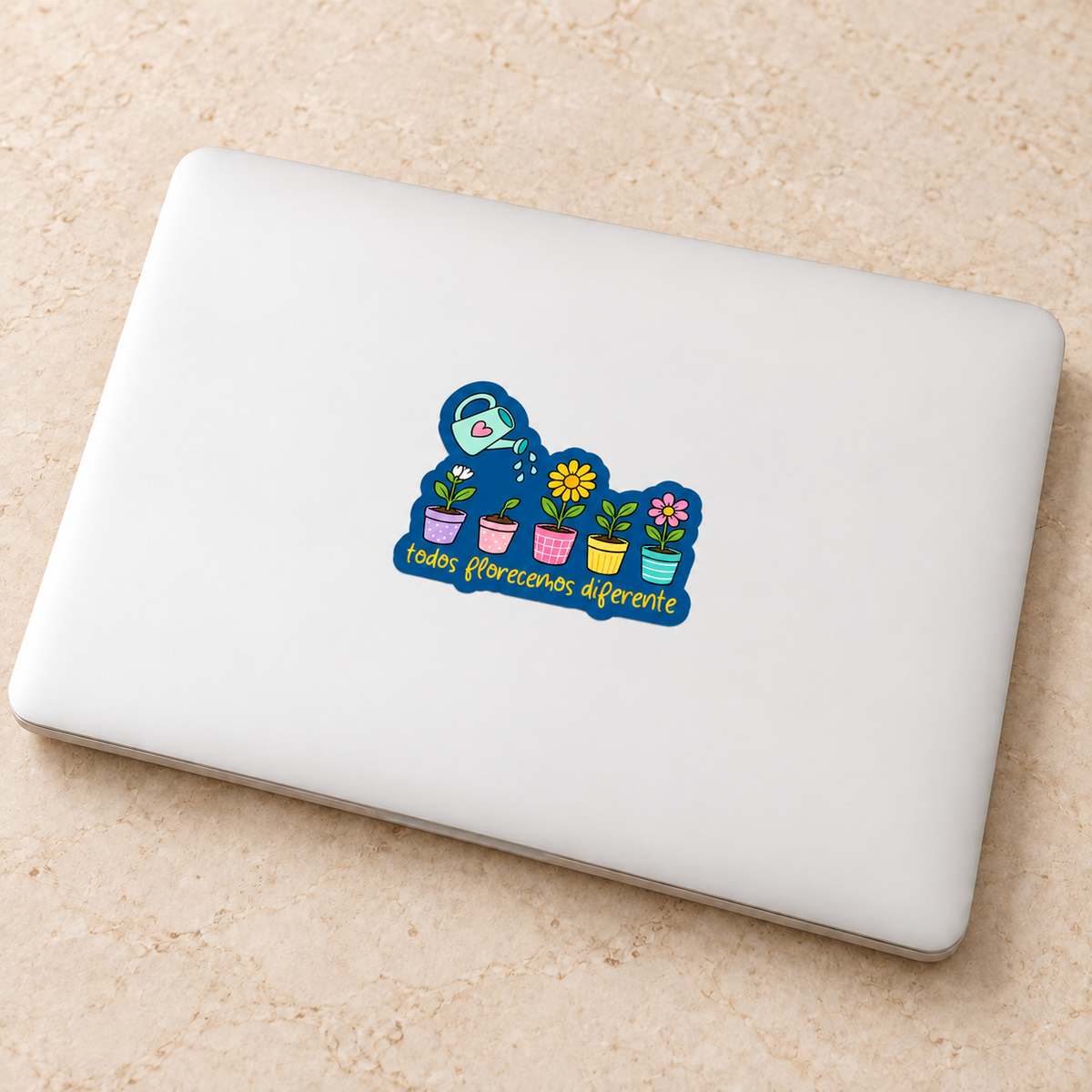 Todos florecemos diferente · Sticker aplicado en laptop